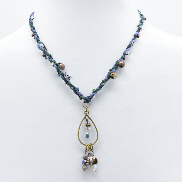 artisan crafted mid length necklace with hand sewn cords from cotton batik fabric braided with cotton cords embellished with crystals and beads and a bronze drop
