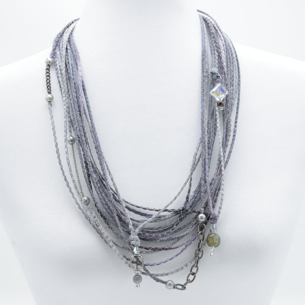 artisan hand crafted long necklace with 14 cords sewn from cotton batik fabric adorned with chain, crystals and beads