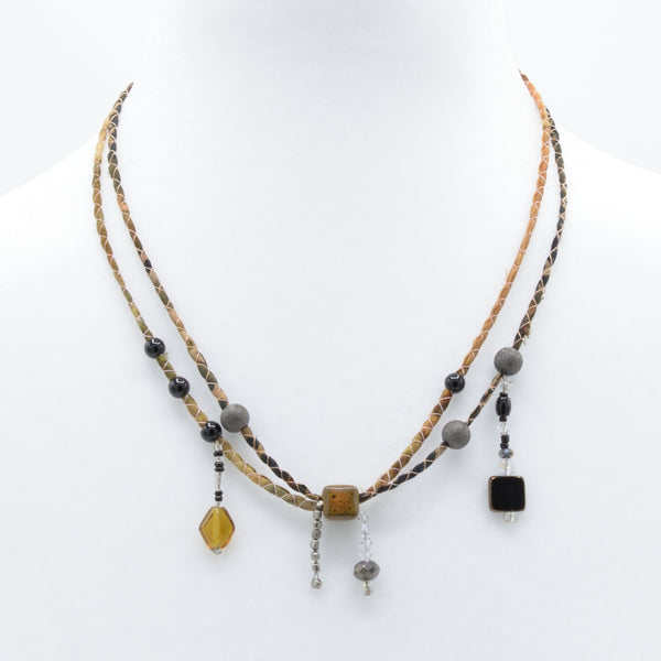 artisan crafted mid necklace with hand sewn cords from cotton batik fabric braided with cotton cords embellished with crystals and beads